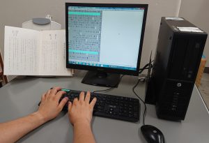 パソコン用点字編集システムで文庫本を点訳している写真