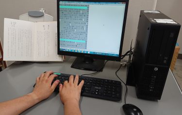 パソコン用点字編集システムで文庫本を点訳している写真